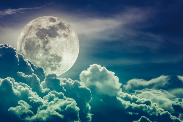 Nighttime sky with clouds and bright full moon with shiny.