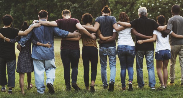 Group of friends huddle in rear view together