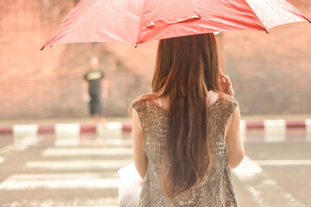 Woman Waiting to Cross Street in Rain with Umbrella