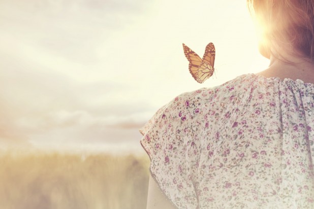 special moment of meeting between a butterfly and a girl in the middle of nature