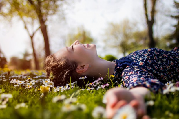 Pretty young teenage girl relaxing on a grass